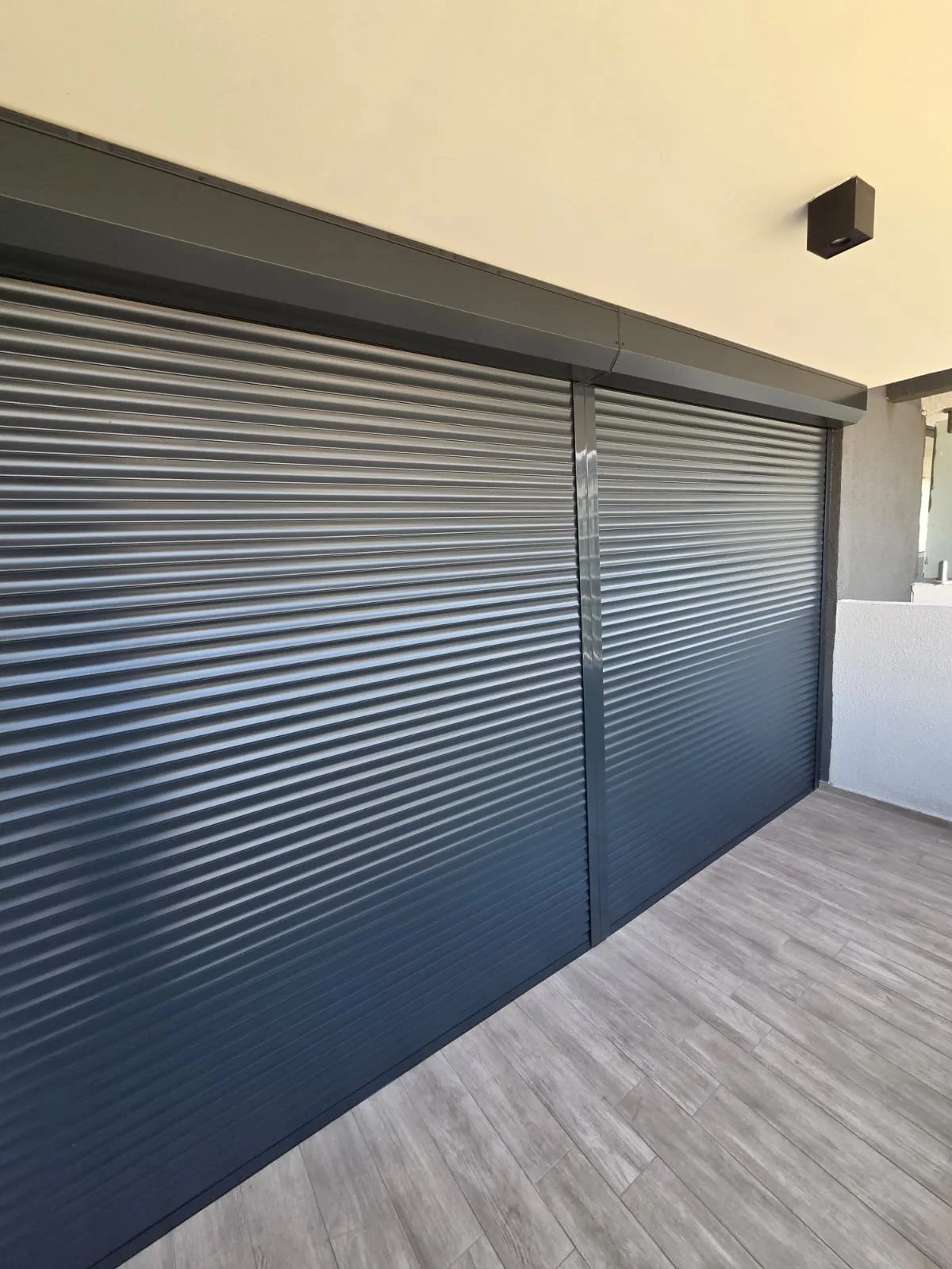Persianas de exterior de aluminio color grafito instaladas por TerraBlinds en una terraza