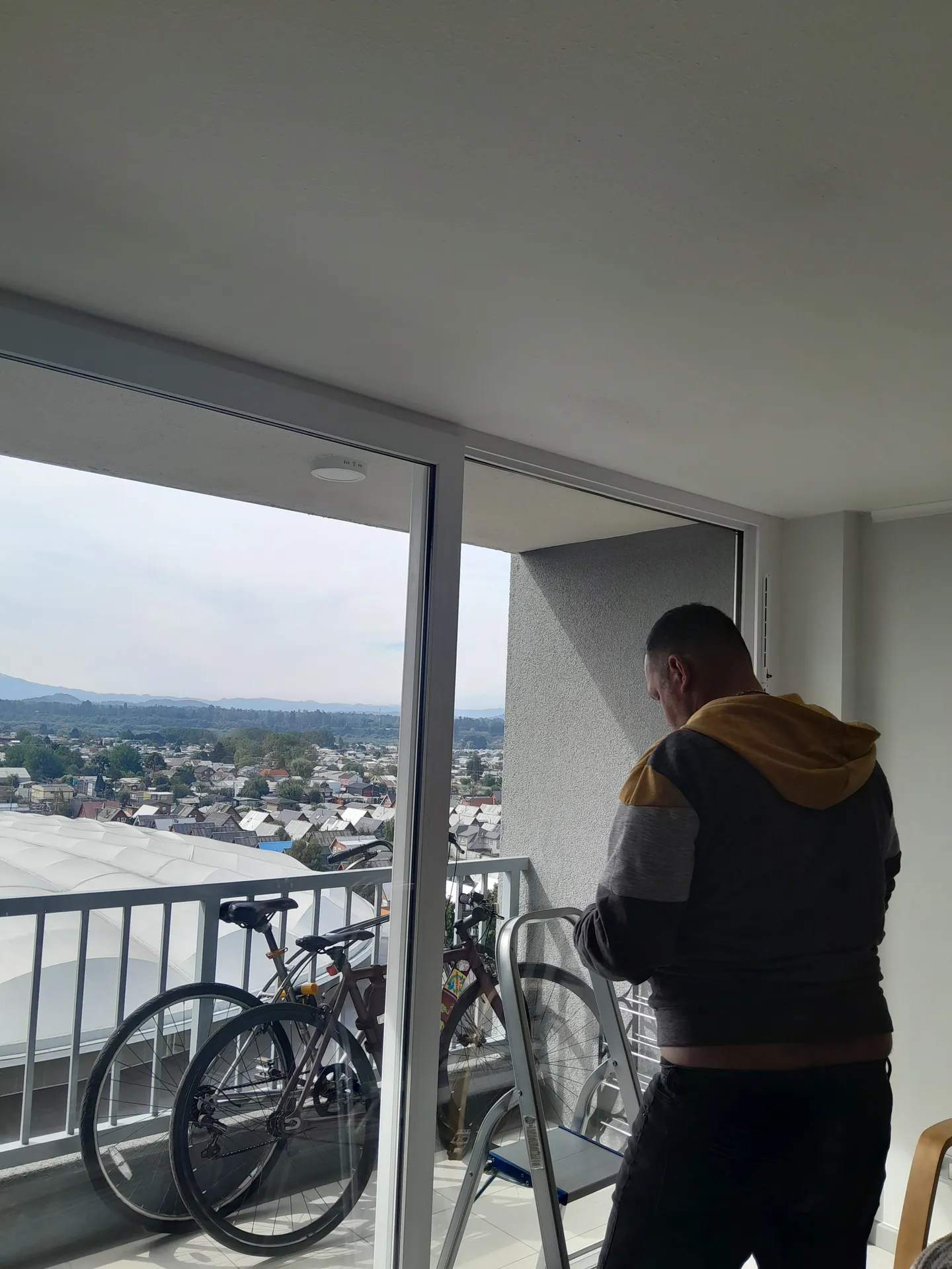 Técnico de TerraBlinds revisando una instalación junto a un ventanal