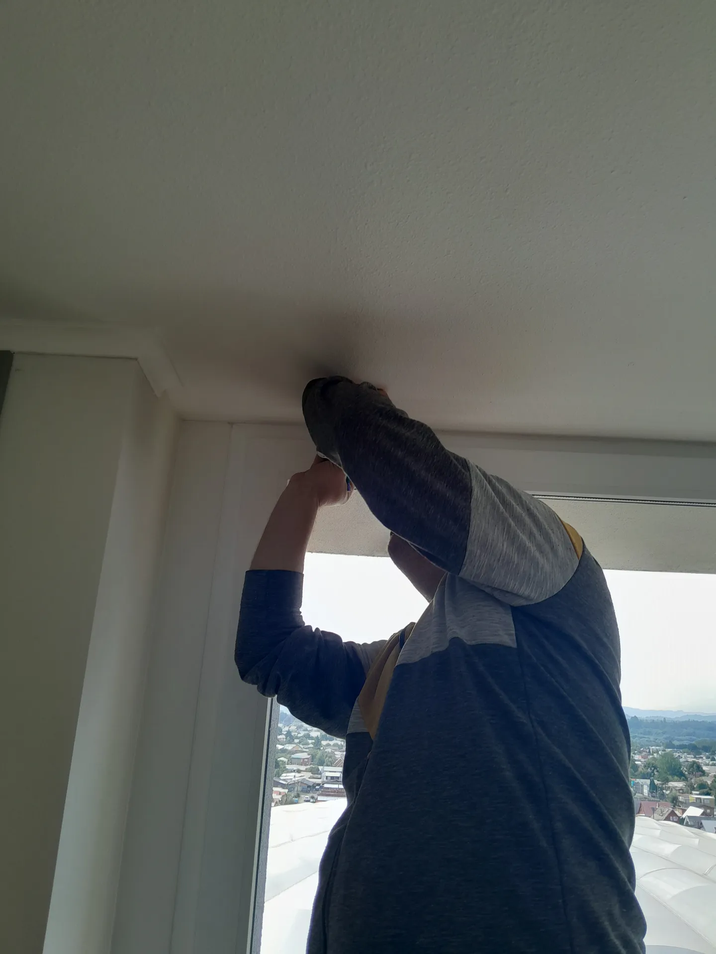 Técnico de TerraBlinds fijando soportes en el marco de una ventana
